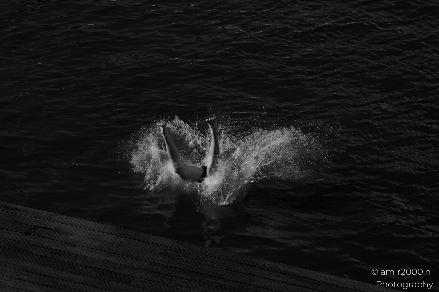 Clean backflip above the canal with shoulders open and face to the sky, black and white
