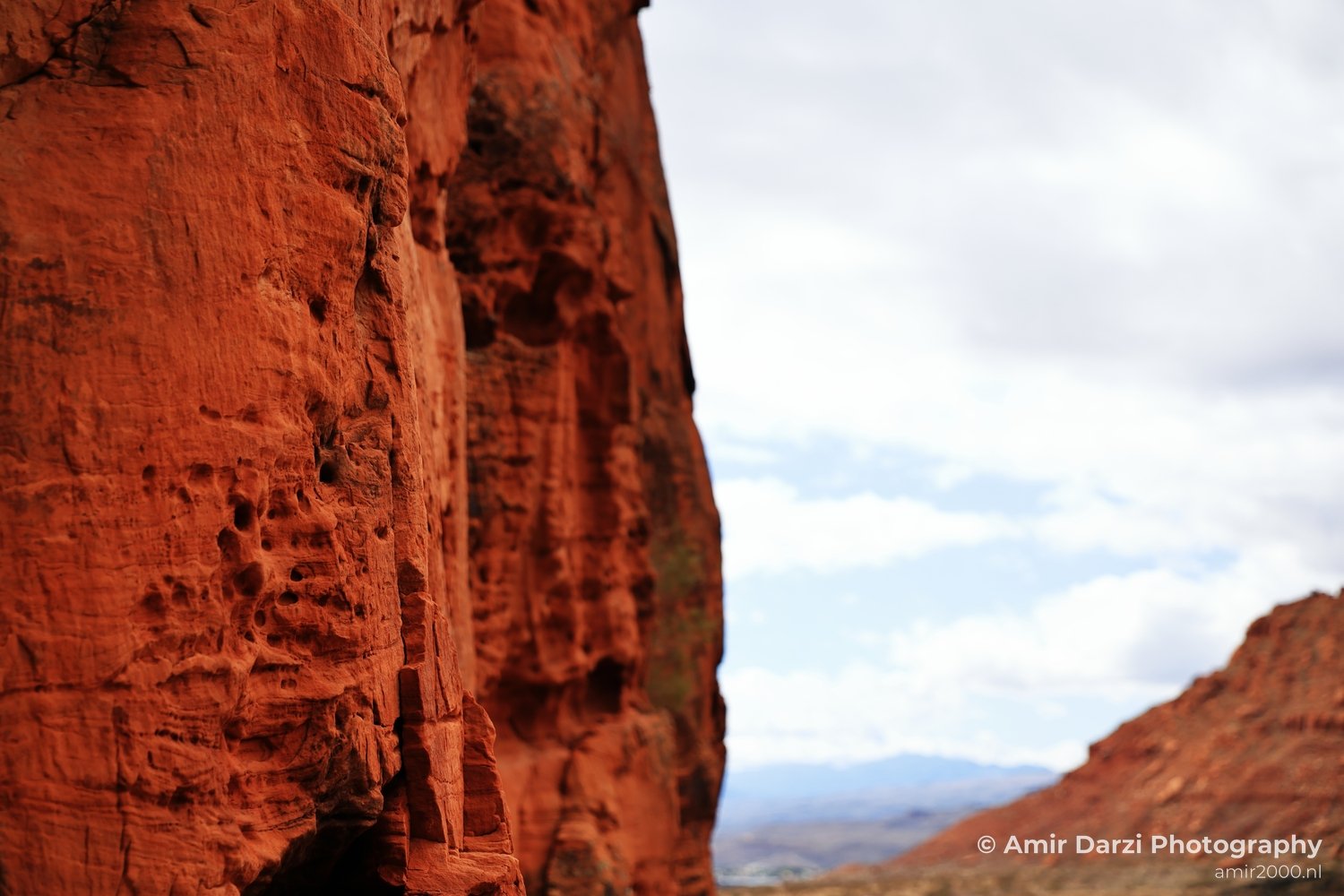 Red sandstone cliff with cloudy sky background at Jenny Canyon Trail.