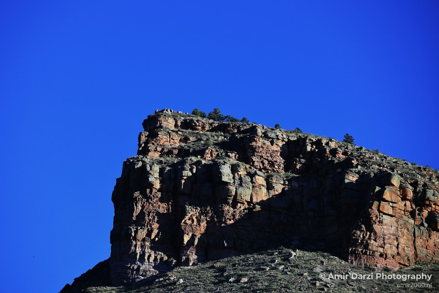 A natural rock formation in Estes Park, Colorado, USA, with a clear blue sky in the background.