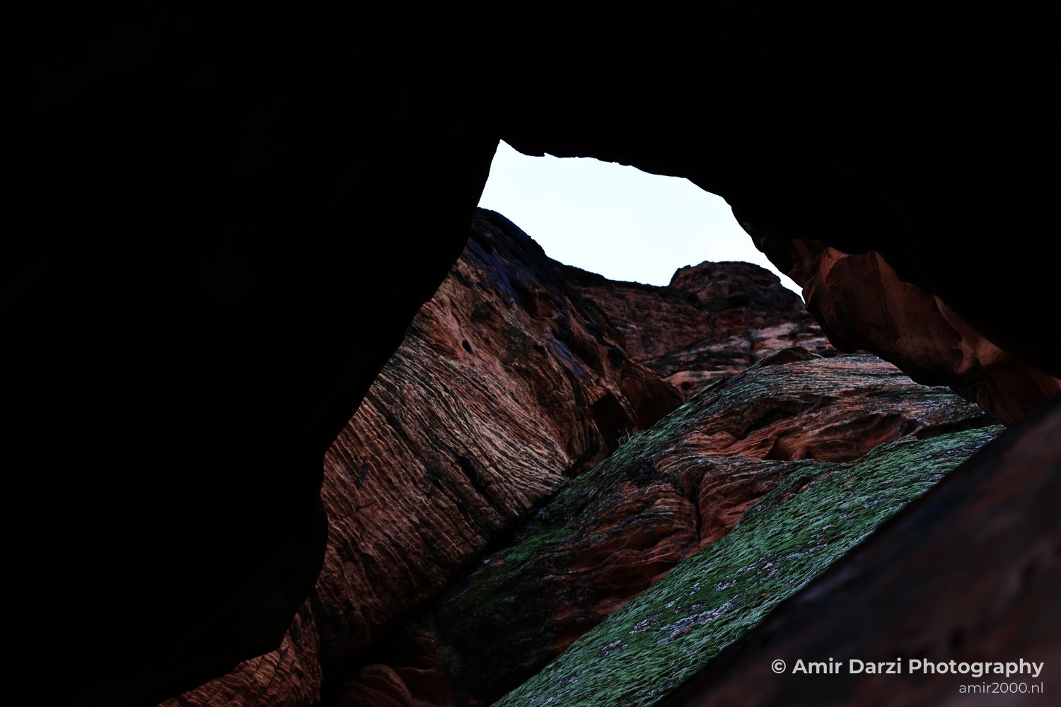 A closeup view of eroded red rock cliffs and sparse vegetation at Snow Canyon State Park near St.