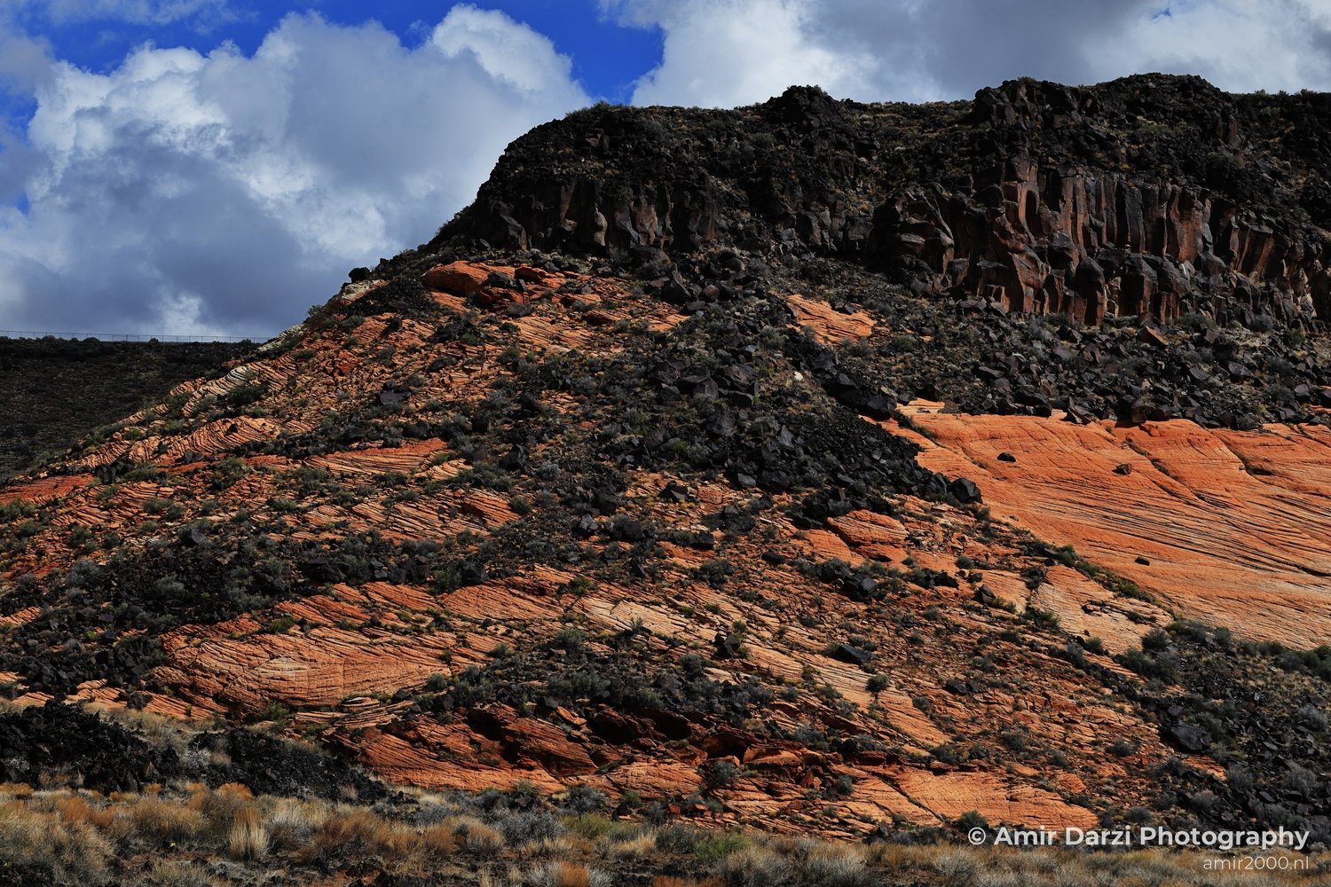 Dry-terrain view of canyon landscape with sparse vegetation across desert ground in St George Utah.