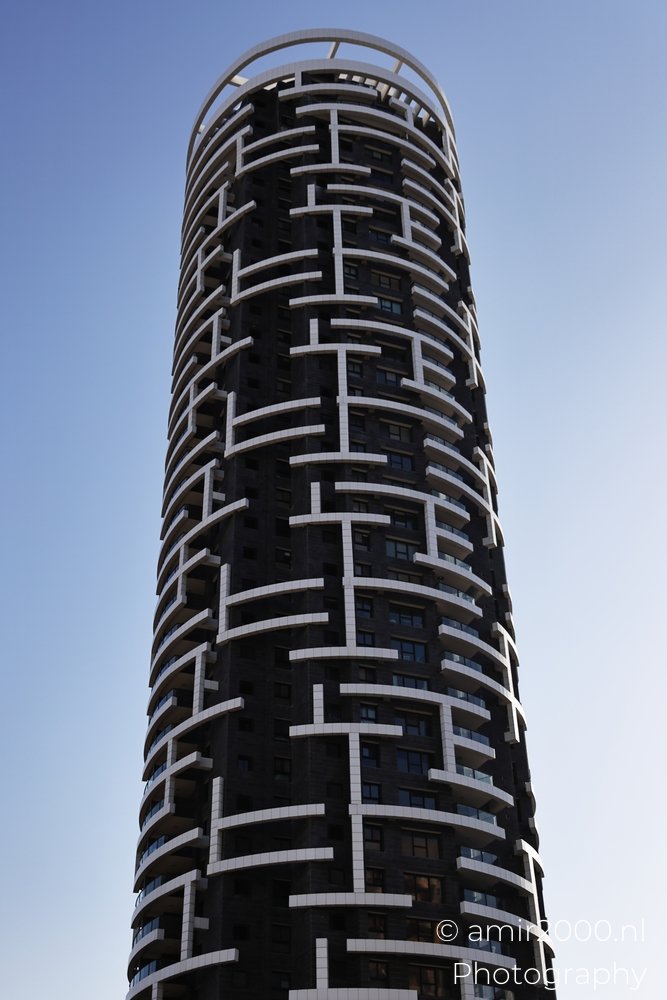 Metro Tower ending its broken facade pattern at a circular crown in Ramat Gan, Israel