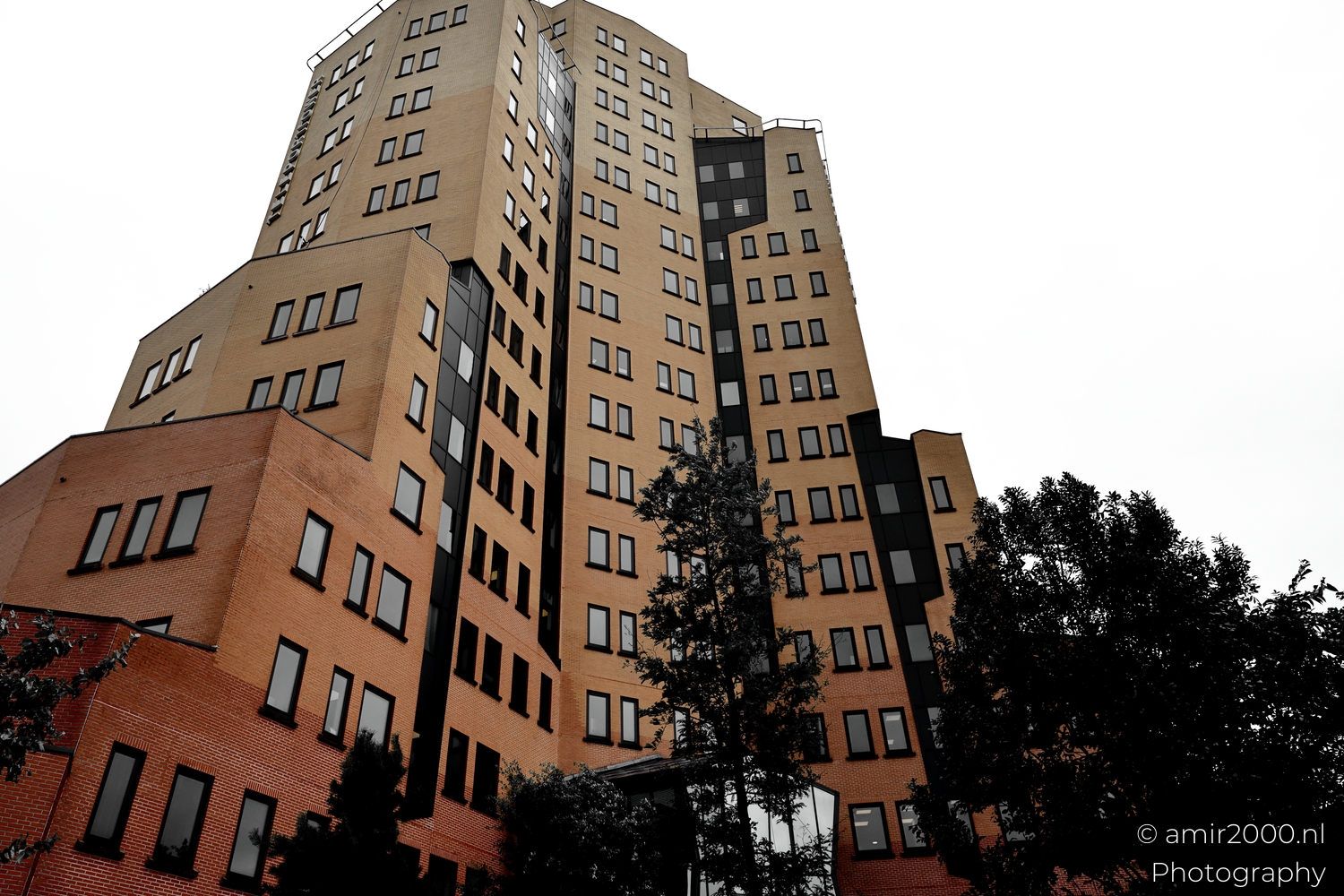 Portrait facade of Teleport Towers with stacked beige volumes and black window strips against a white sky