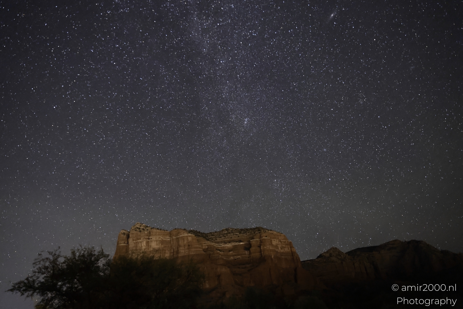 Milky Way streak above sandstone ridge, fine star texture, deep night tones, wide composition
