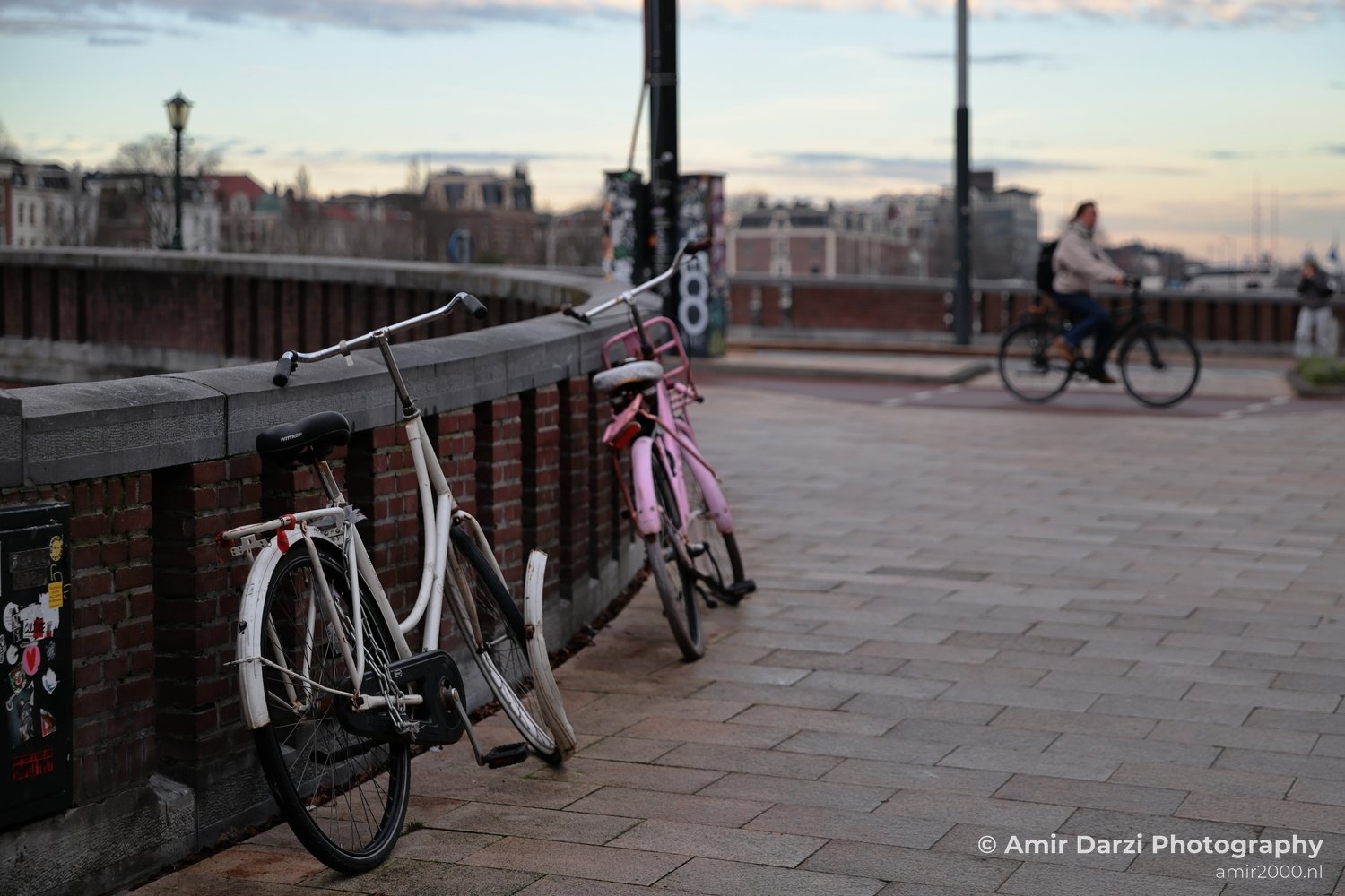 A sunrise scene featuring two bikes and a cyclist near Amsterdam Netherlands.