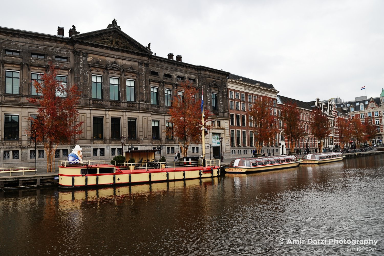 Historic buildings and tour boats on a canal near the Turfdraagsterpad area of Amsterdam.