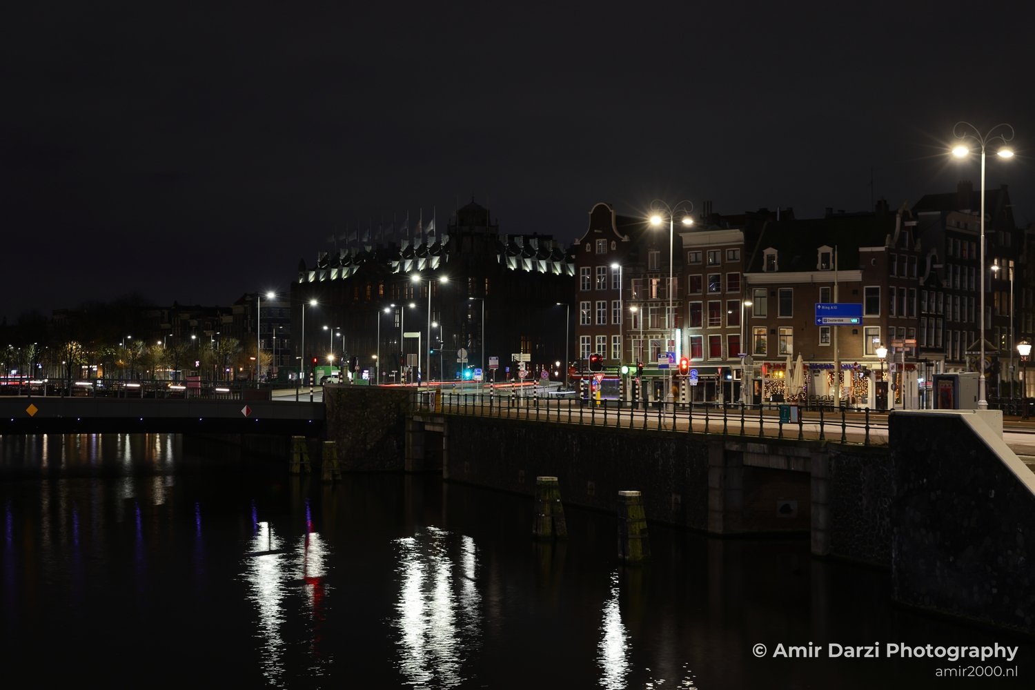 Reflections on the water at nighttime over an urban Dutch cityscape in Amsterdam Netherlands.