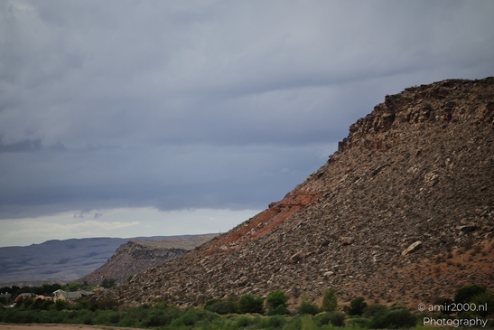A rocky hill with sparse desert vegetation under a cloudy sky. - image from year 2025 #002