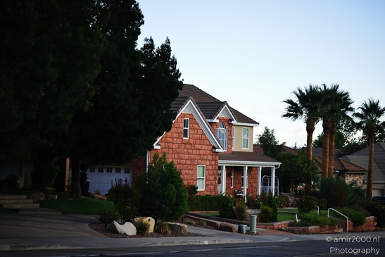 A red-brick house with a white front door and porch in a suburban neighborhood. - image from year 2025 #003