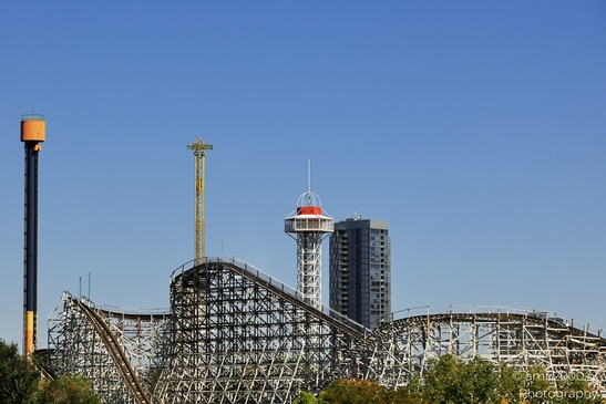Cityscape and clear blue sky Colorful roller coaster with red and white tower against the cityscape image from year 2025 #6