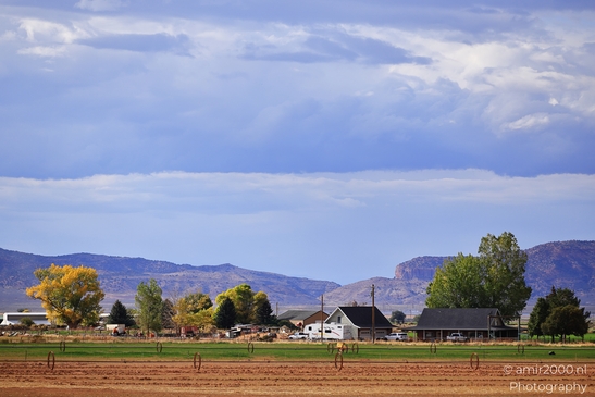 A rural farm with mountains in the background under a blue sky. - image from year 2025 #001