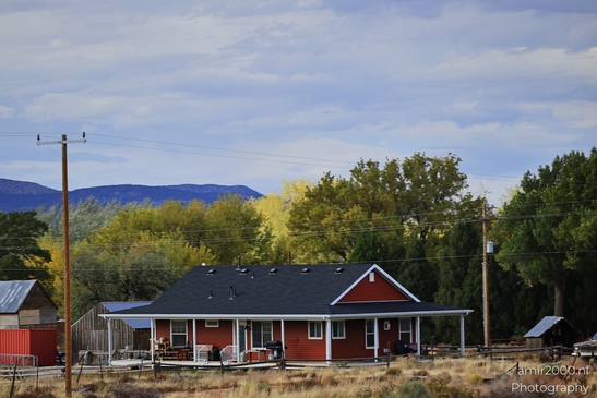 A rural house with a porch and solar panels overlooks autumn foliage in Utah. - image from year 2025 #004