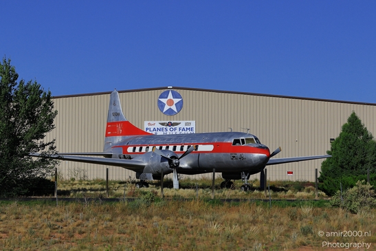 Small places on the go road trip in Arizona USA. A vintage airplane parked in front of a hangar, - image from year 2025 #015