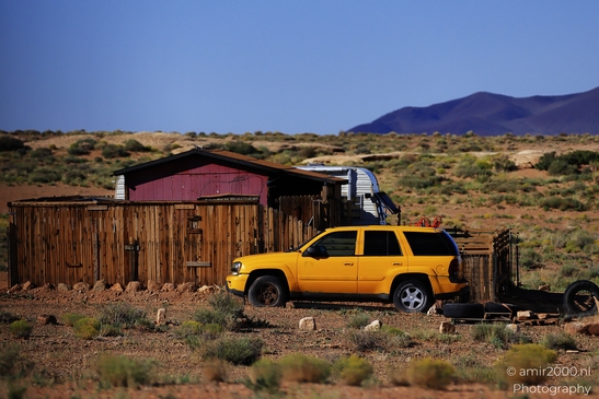 Small places on the go road trip in Arizona USA. A yellow SUV parked in a desert town. - image from year 2025 #017