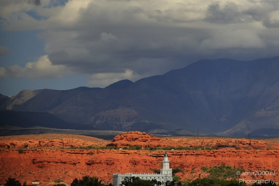 A white spire stands out against a backdrop of rocky desert terrain and dark mountains under - image from year 2025 #004