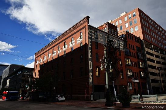 A red-brick industrial structure with large white lettering stands prominently in an urban - image from year 2025 #022