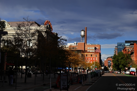 With street lights and sidewalks in view, an passes through a town-center block in Denver - image from year 2025 #025