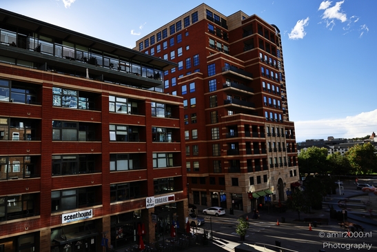 Against intersections and storefronts, an passes through a town-center block in Denver Colorado - image from year 2025 #027
