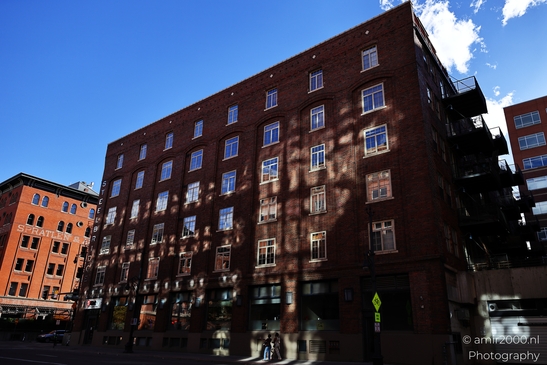 A multi-story redbrick building with windows and balconies in a vibrant cityscape. - image from year 2025 #030