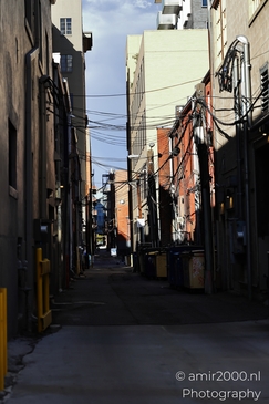 A narrow alleyway in Denver's downtown area with various buildings and utility lines. - image from year 2025 #035