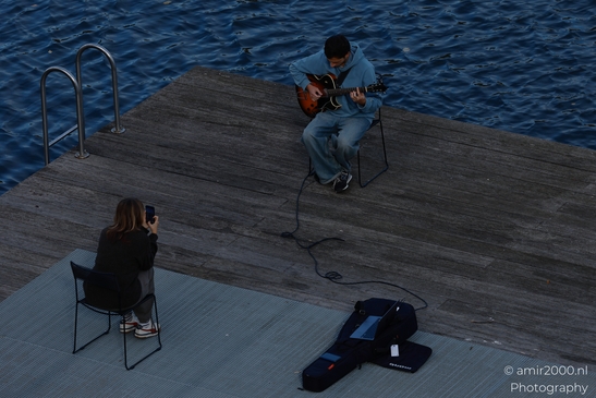Man_Playing_Guitar_On_Wooden_Dock_At_Dusk_On_Canal_Edge_Amsterdam_Netherlands_People_Creative_Collection_Photography_Canon_EOS_R5_Mark_II_2025_003.JPG