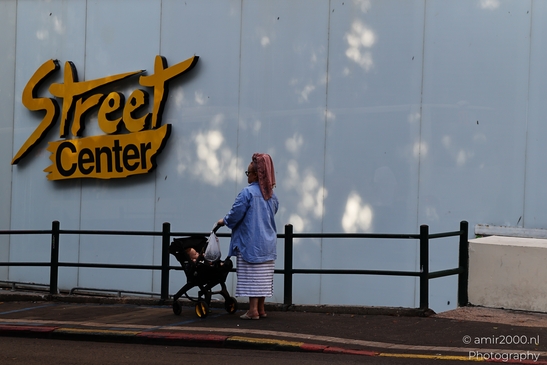 Street_Center_Signage_With_Woman_And_Child_In_Stroller_Tel_Aviv_jaffa_Israel_People_Creative_Collection_Photography_Canon_EOS_R5_Mark_II_2025_001.JPG