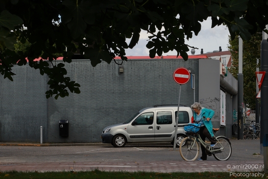 A bicyclist navigates through a busy street in Amsterdam, Netherlands, surrounded by urban - image from year 2025 #003