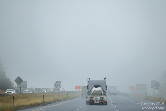 A semi-truck drives through a foggy highway in Colorado. - image from year 2025 #001