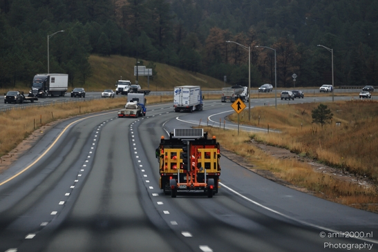 A highway with various vehicles including a construction truck in focus. - image from year 2025 #001