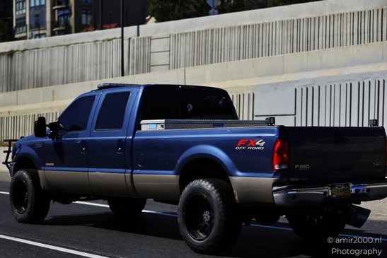 A dark-colored pickup truck with 'FX4 Off Road' decals parked on a highway. - image from year 2025 #003