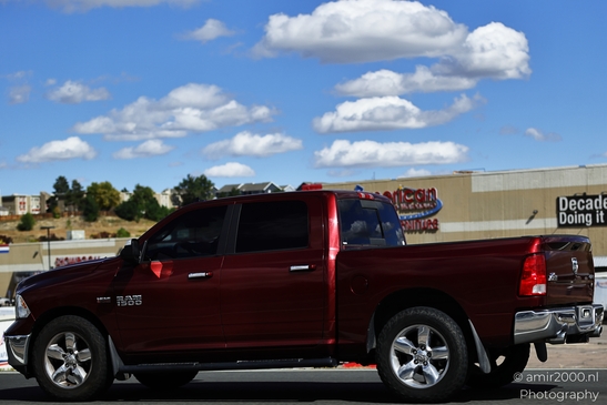 A red Dodge Ram 1500 parked on a street near an American Eagle Outfitters store. - image from year 2025 #009