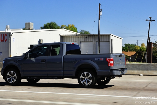 The Highway around Denver Colorado Blue Ford truck on road with clear sky and trees in background image from year 2025 #7