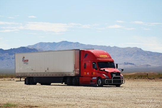 Trucks In Western USA in Transportation Collection. A red semi-truck parked in a desert setting. - image from year 2025 #008