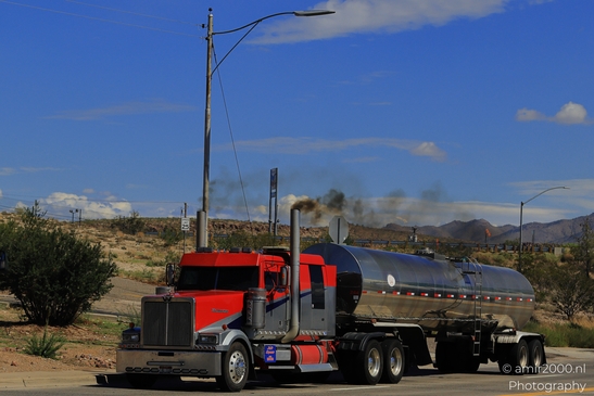 Trucks In Western USA in Transportation Collection. A red semi-truck driving down a desert - image from year 2025 #012