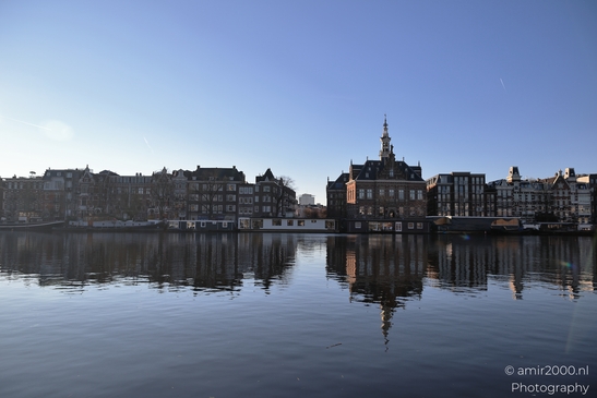 Reflections of historic buildings on a calm canal in Amsterdam Netherlands. - image from year 2025 #004