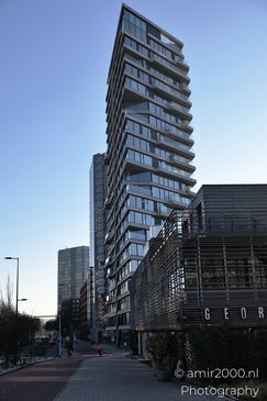 A modern high-rise building with a unique design in an urban setting. - image from year 2025 #001