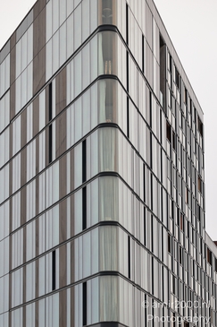 A modern glass-fronted building with a reflective facade in an urban setting. - image from year 2025 #002