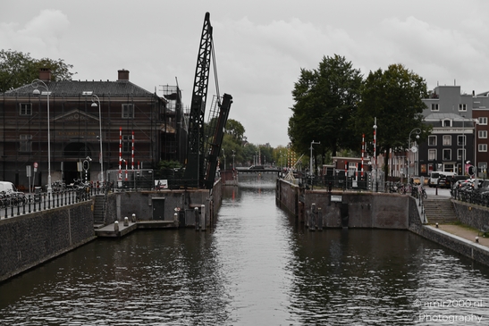 A typical canal scene in Amsterdam's city center, with a bridge and buildings lining the - image from year 2025 #001