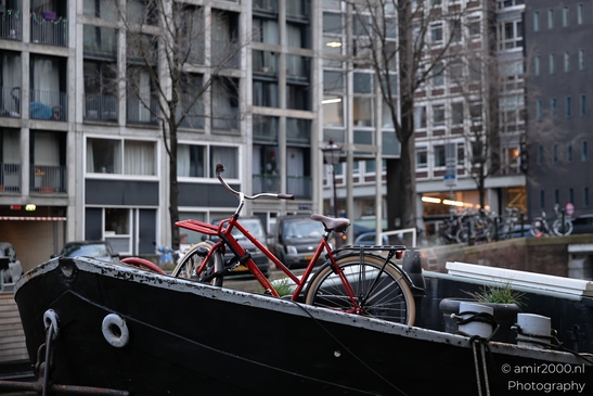 Red_Bicycle_On_A_Boat_In_Urban_Canal_Setting_Amsterdam_Netherlands_Cityscape_Photography_Canon_EOS_R5_Mark_II_2025_001.JPG