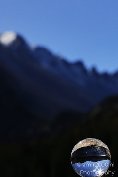 A glass ball shows a crisp reflected ridgeline as reflected natural contours frames the scene in - image from year 2025 #004