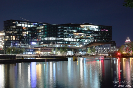 The Booking.com campus offices in Amsterdam, Netherlands at night, with a reflection of lights - image from year 2025 #001