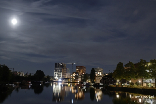 Nighttime view across Amsterdam's Oostelijke Eilanden and Kadijken, with illuminated buildings - image from year 2025 #001