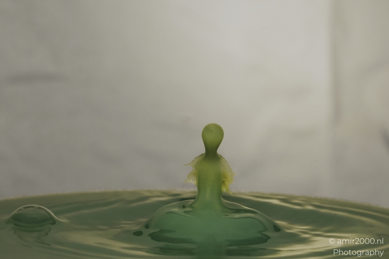 Water drops in a creative series, with yellow dancing droplets colliding in an artistic display - image from year 2025 #023