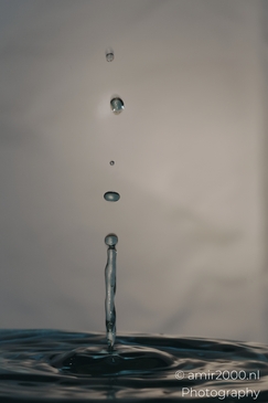 A single water droplet splashing into another, creating a crown of ephemeral beauty in this - image from year 2025 #032
