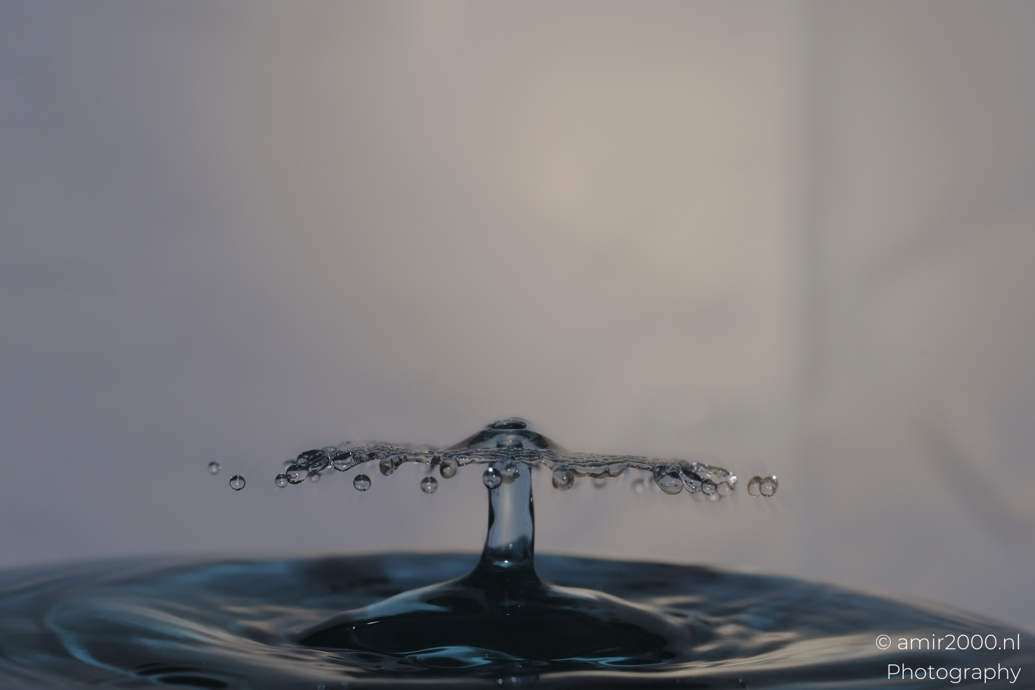 Blue water umbrella on thin column, side view, studio light, crisp droplets