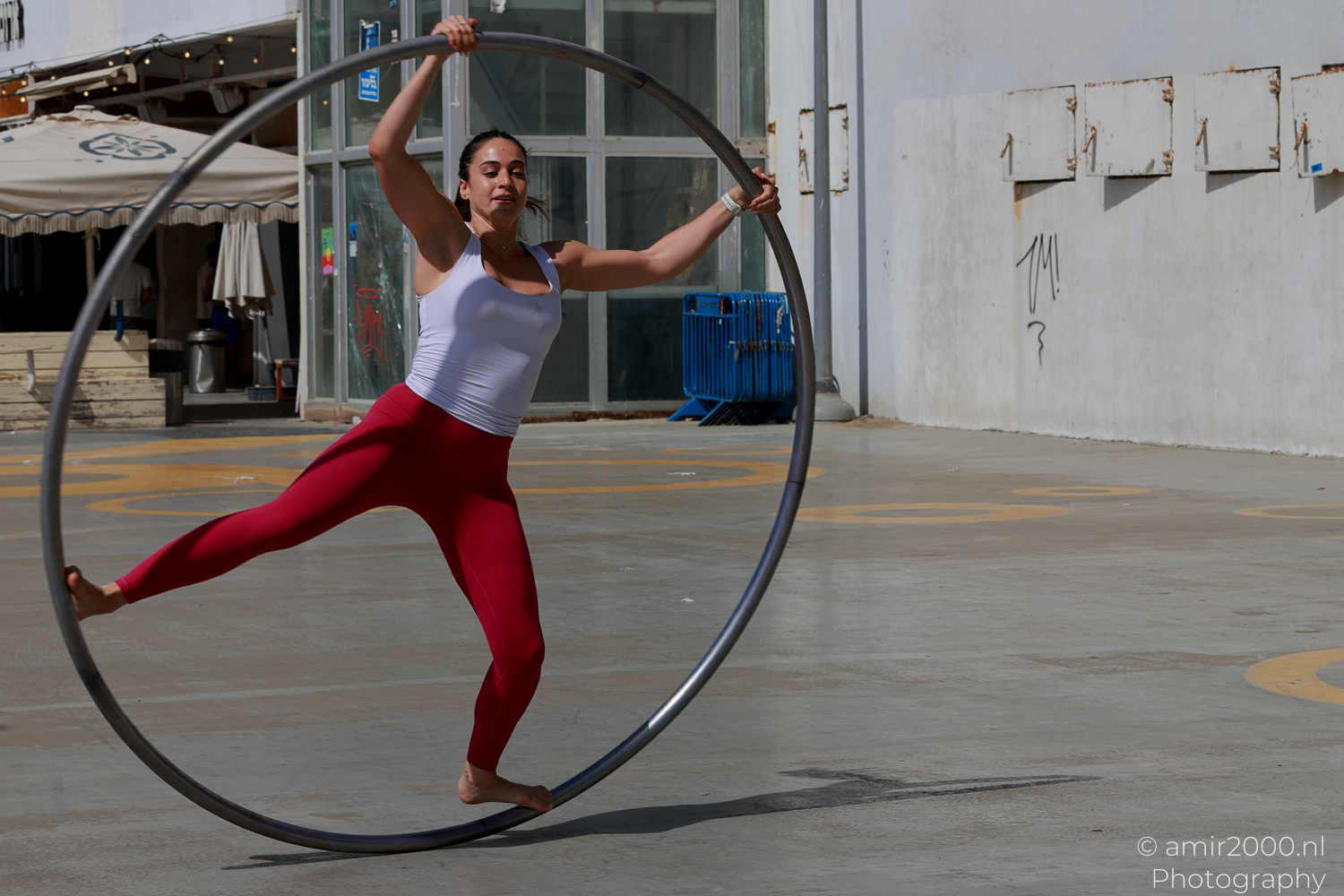Barefoot female Cyr wheel acrobat balancing on the rim in Tel Aviv-Jaffa