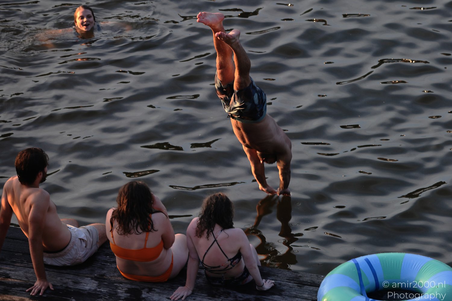 People cooling off beside an Amsterdam canal on a hot day