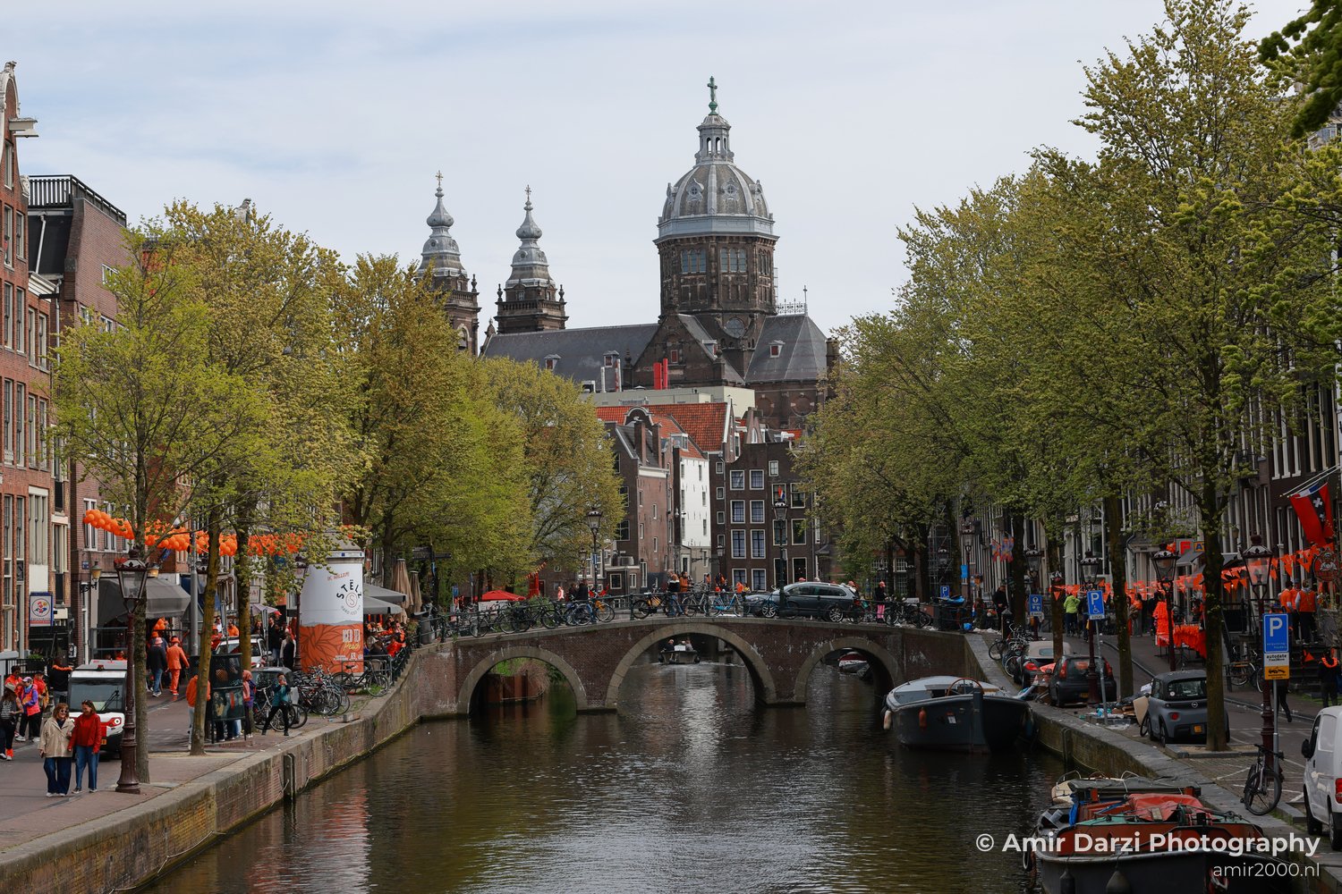 King’s Day celebration in Amsterdam with boats and spectators in a crowded celebration scene.