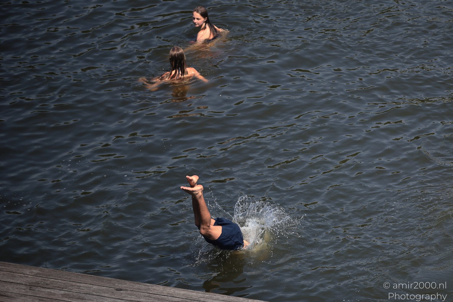 Man completing a head-first jump into an Amsterdam canal