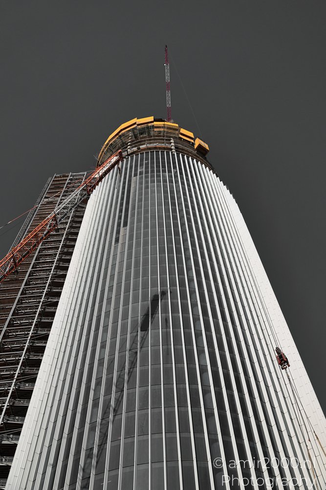 Azrieli Spiral Tower rising beside scaffolding with an unfinished crown in Tel Aviv-Jaffa